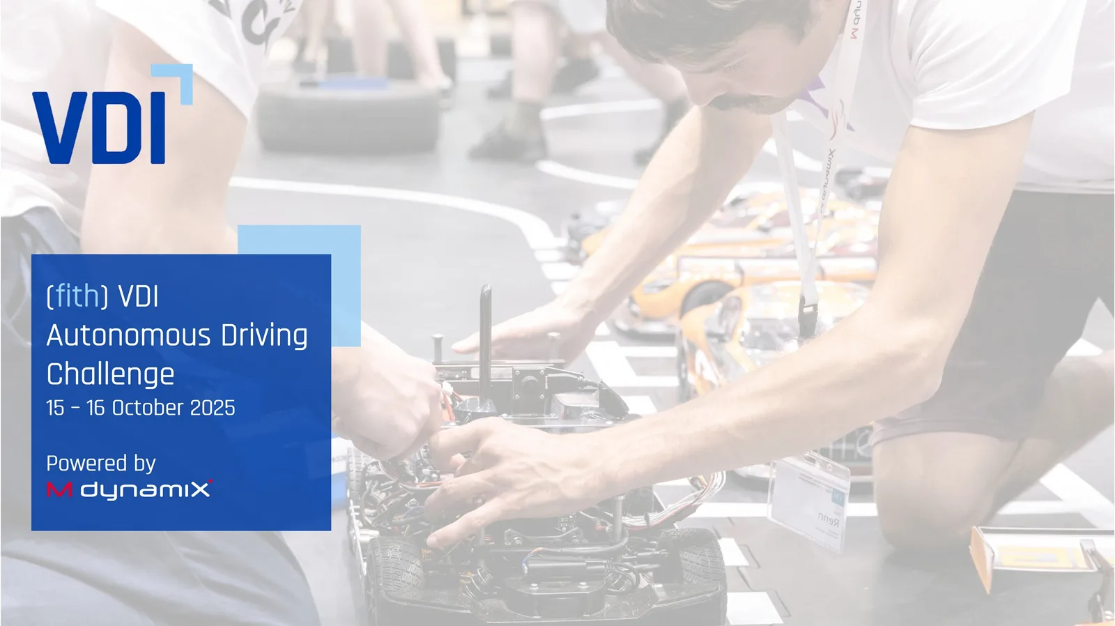 Modellfahrzeug im Maßstab 1:8, das MXcarkit ohne Karosserie ist zu sehen, an dem ein Student etwas justiert. Davor der Schriftzug: "(fith) VDI Autonomous Driving Challenge; 15.-16. October 2025