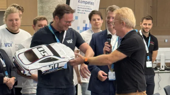 Zu sehen ist Alexander Bloch bei der VDI Autonomous Driving Challenge 2025, powered by MdynamiX. Ihm wird von Markus Krug die Karosserie des 
