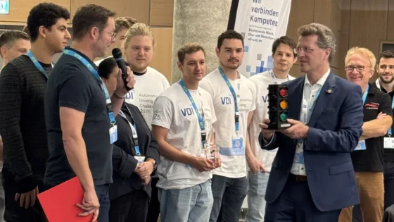 Lutz Eckstein, Präsident des VDI, übergibt dem Siegerteam der HS München ihren Siegerpreis, das MXtrafficlightsystem.