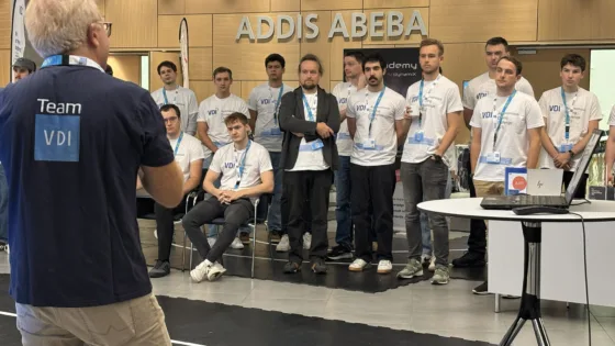 Professor Markus Krug eröffnet die VDI Autonomous Driving Challenge 2025 bei der ELIV in Bonn. Vor ihm stehen alle Studierenden des diesjährigen Wettbewerbs im Halbkreis.