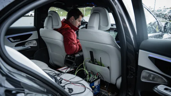 Testingenieur des IFM richtet die Messtechnik in einem Testfahrzeug für den ADAS-Benchmark ein.