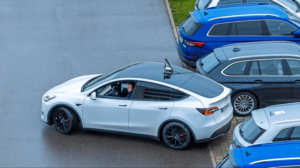 Ein einparkendes Fahrzeug mit einer GPS-Antennen auf dem Fahrzeugdach zur zentimetergenauen Positions- und Ausrichtungsbestimmung mittels Differential-GPS im ADAS-Benchmark.