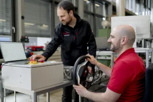 Ingenieure testen ein Steer-by-Wire-Fahrwerkssystem mit Force-Feedback-Aktuator im Fahrdynamik-Prüfstand zur Entwicklung und Validierung von Lenk- und Fahrwerksfunktionen.