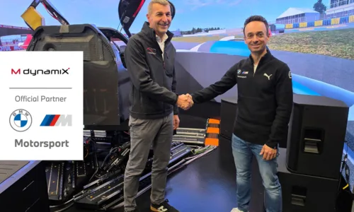 Vertreter von MdynamiX und BMW M Motorsport besiegeln ihre technische Partnerschaft für virtuelle Fahrerlebnisentwicklung per Handschlag vor einem High-End-Fahrsimulator. Im Fokus stehen hochpräzise Lenksystemsimulation, Force-Feedback-Technologie und realistische Fahrerlebnisentwicklung im Motorsport.