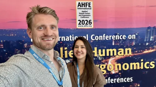 Zwei MdynamiX-Mitarbeitende (Tristan Schwandke, Seda Aydogdu) auf der AHFE 2026 in Istanbul vor dem Konferenzbanner der International Conference on Applied Human Factors and Ergonomics.