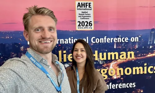 Two MdynamiX employees (Tristan Schwandke and Seda Aydogdu) at AHFE 2026 in Istanbul in front of the conference backdrop of the International Conference on Applied Human Factors and Ergonomics.